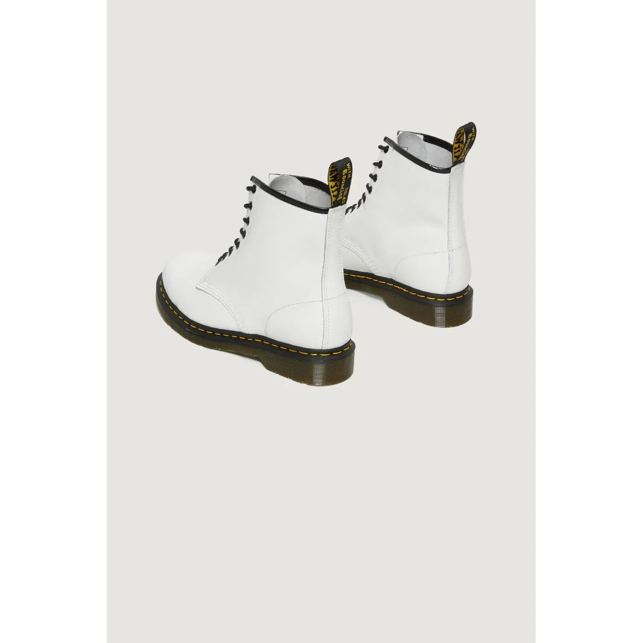 Anfibi bianchi da donna in pelle, suola nera con cuciture gialle, moda casual trendy.