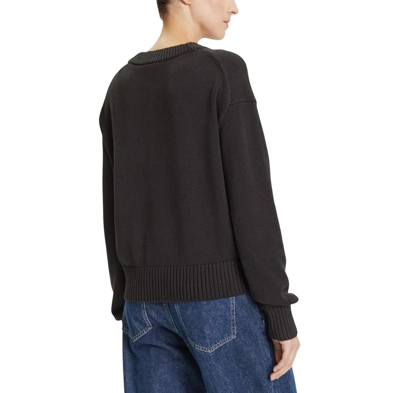 Maglione nero donna a maniche lunghe in maglia, indossato con jeans blu, vista posteriore