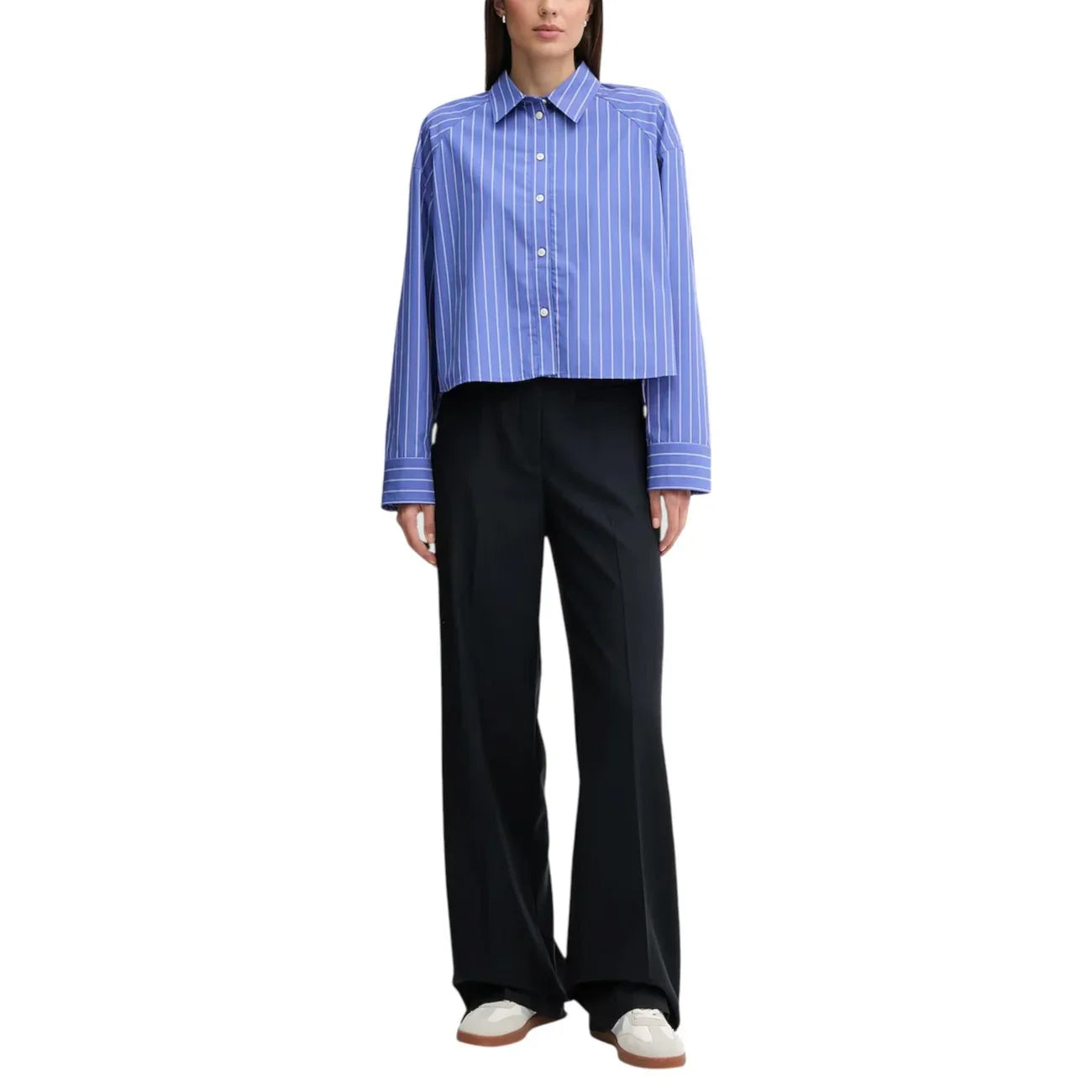 Donna con camicia a righe blu e pantaloni neri larghi, outfit moda donna elegante.