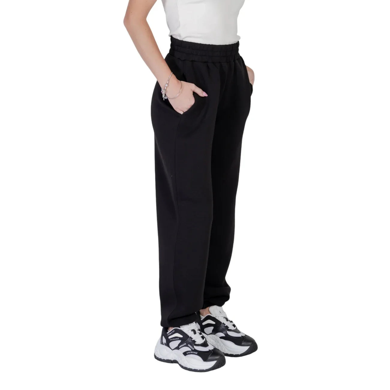 Pantaloni neri donna in tessuto felpato, vestibilità comoda, abbinati a sneakers trendy