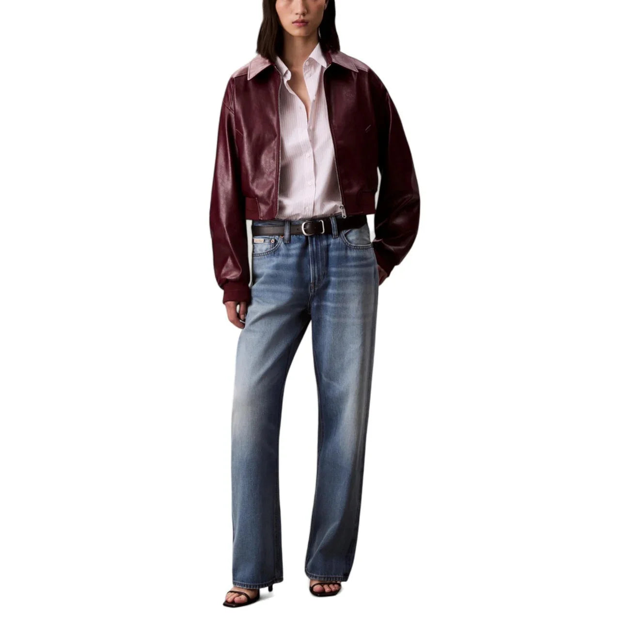 Donna con giacca in ecopelle bordeaux, camicia rosa e jeans larghi, moda casual elegante