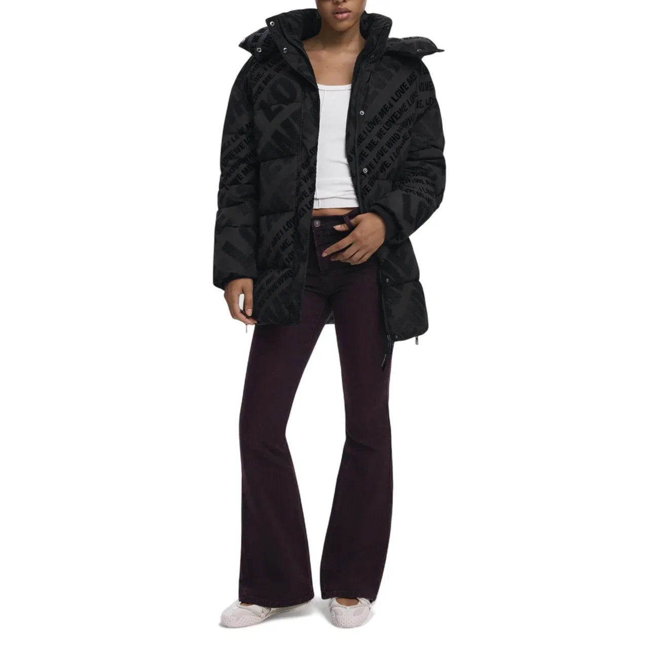 Giacca puffer nera donna con scritte, top bianco e pantaloni svasati viola, moda autunno inverno